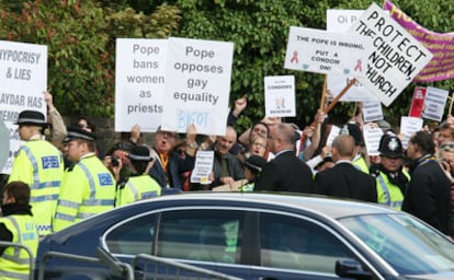 Un grupo de personas protesta esta mañana en Londres al paso del vehículo en el que viajaba el Papa.