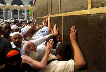 Peregrinos musulmanes tocan la reliquia más sagrada del Islam, La Kaaba, en la Gran Mezquita de La Meca.