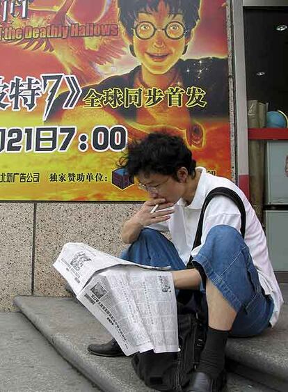 Un joven lee ante un cartel promocional del libro <i>Harry Potter and the Deathly Hallows</i> hace unos días en Pekín.