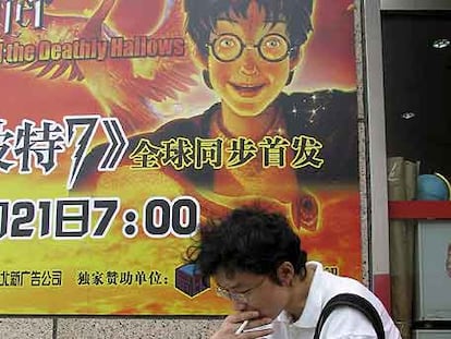 Un joven lee ante un cartel promocional del libro <i>Harry Potter and the Deathly Hallows</i> hace unos días en Pekín.