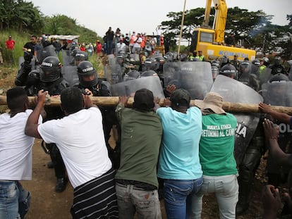 Un grupo de personas se enfrenta a la policía durante el desalojo de una invasión de tierras en Navarro, Colombia, el pasado 6 de octubre.