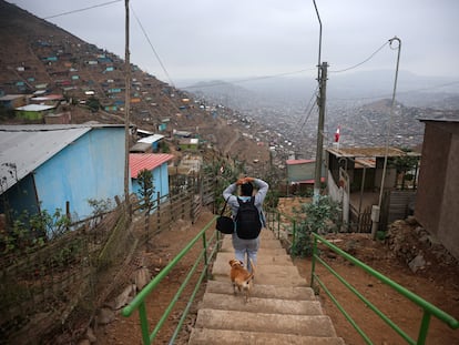 Una mujer baja las escaleras después de cruzar los restos del 'muro de la vergüenza' en Lima, Perú, el 31 de agosto 2023.