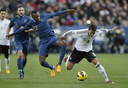 El alemán Mesut Özil (derecha) retiene el balón ante el francés Blaise Matuidi.