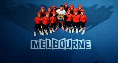  Stanislas Wawrinka posa con el trofeo y los recogepelotas de torneo. 