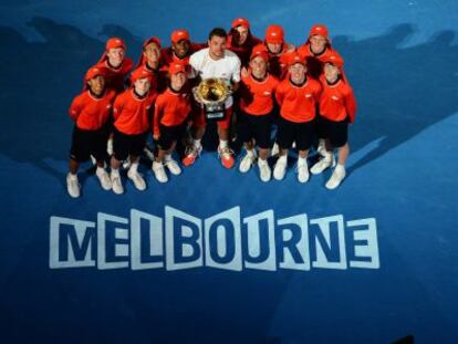  Stanislas Wawrinka posa con el trofeo y los recogepelotas de torneo. 