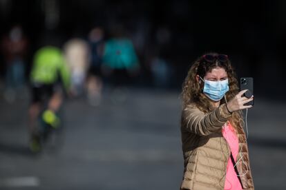 Una mujer con mascarilla se hace una foto con el móvil en el segundo día de desconfinamiento en Madrid.