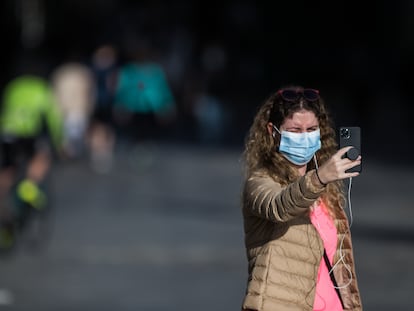 Una mujer con mascarilla se hace una foto con el móvil en el segundo día de desconfinamiento en Madrid.
