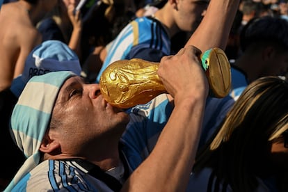 Mundial Qatar 2022: Un aficionado besa una réplica de la copa del mundo al celebrar la victoria argentina frente a Croacia en Buenos Aires