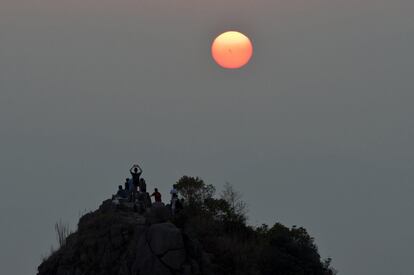 Un grupo de personas fotografía la puesta de sol en Hong Kong en el cuarto día de la festividad del Año Nuevo Lunar.