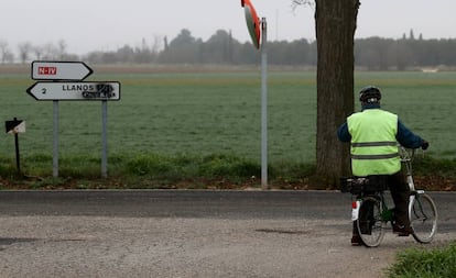 Un ciclista se detiene frente al cartel que señala el camino hacia Llanos del Caudillo.