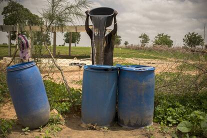 Una mujer recoge agua de una cisterna para regar su huerta en Keur Bara (Senegal). 