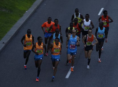 Un grupo de maratonianos corre por las calles de Madrid.