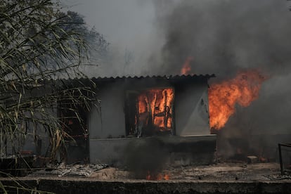 Una vivienda arde por el incendio forestal en Nea Penteli, cerca de Atenas, el lunes.