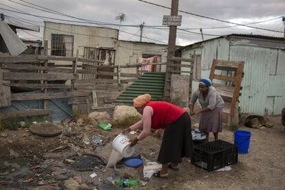 Una mujer arroja agua usada en un asentamiento cerca de Ciudad del Cabo el viernes 2 de febrero de 2018.