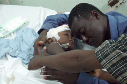 Un haitiano abraza a su hijo, internado en el hospital Darío Contreras, en Santo Domingo Este.