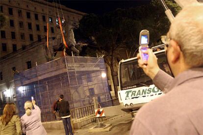 Algunos transeúntes no pudieron evitar la tentación de guardar la última fotografía de la estatua ecuestre de Franco en Madrid.