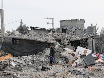 Un menor pasa frente a los escombros de una casa destruida por un misil en Gaza.