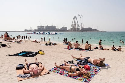 Turistas ajenos al bullicio de las obras en la isla artificial Bluewaters, donde se erigirá la noria The Dubai Eye.