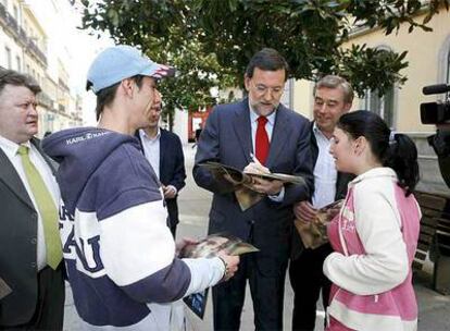 El líder del PP, Mariano Rajoy, firma autógrafos a unos admiradores en las calles de Lugo, hasta donde se ha desplazado para cubrir la parte final de la campaña