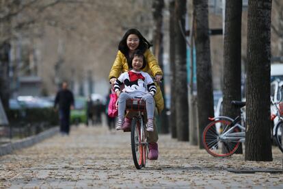 Una mujer y una niña disfrutan de un paseo en bicicleta en el parque Ritan Park en Pekín (China), el 11 de marzo de 2017.