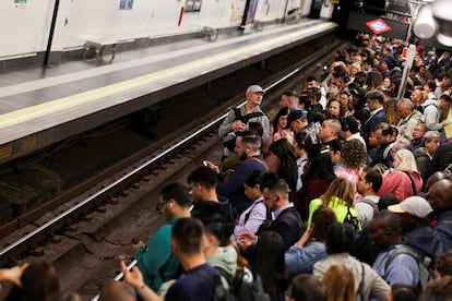 Usuarios de Metro de Madrid esperan en un andén para la llegada de un vagón, este martes.