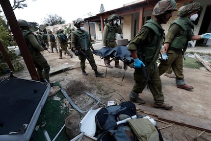 Soldados israelíes retiran cadáveres del kibutz de Kfar Aza atacado por Hamás, el pasado martes.