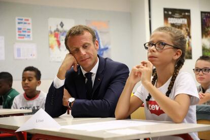 El presidente Emmanuel Macron se sienta junto a una alumna durante su visita a una escuela de secundaria en Laval (Francia) en el primer día de colegio. 