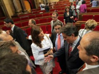 Alicia Sánchez-Camacho (PP) junto a Felip Puig en primer plano conversa con Artur Mas en un receso en el Parlament.