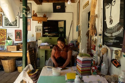 Petrona Hernández Jiménez pega las portadas de las libretas que venden en el taller.