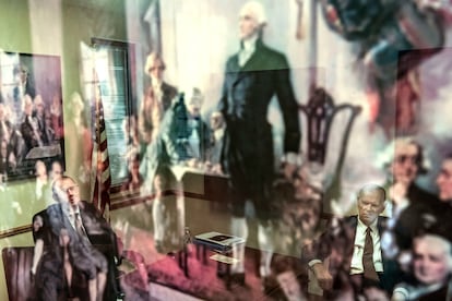Art Thompson, a retired John Birch Society CEO, right, and current CEO Bill Hahn, left, are reflected in a poster of George Washington hanging in Hahn's office during an interview at the organization's headquarters in Appleton, Wis., Thursday, Nov. 17, 2022.
