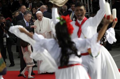 El papa Francisco (d), acompañado del presidente de Colombia, Juan Manuel Santos (i), observa la presentación de un grupo de danza folclórica durante su recibimiento a la base aérea de Catam.