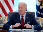 FILE - In this Jan. 28, 2021 file photo, President Joe Biden signs a series of executive orders in the Oval Office of the White House in Washington. Biden campaigned on raising the national minimum wage to $15 per hour and attached a proposal doing just that to the $1.9 trillion coronavirus pandemic relief bill. (AP Photo/Evan Vucci)