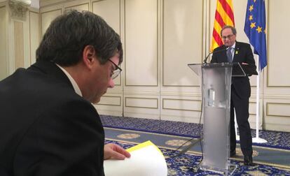 Torra interviene en un hotel de Bruselas mientras Puigdemont revisa sus notas.