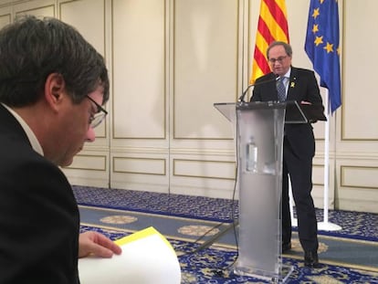 Torra interviene en un hotel de Bruselas mientras Puigdemont revisa sus notas.