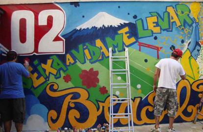 Grafiteros terminan dibujos en una de las calles de Río de Janeiro. Este año, emisoras de televisión, empresas y una marca de cerveza patrocinan concursos que va a premiar a los mejores dibujos.