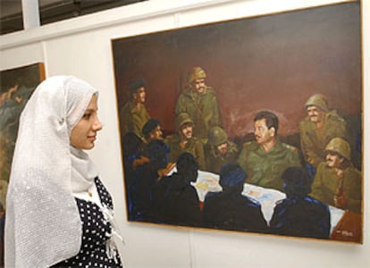Una joven iraquí observa un cuadro en el que aparece Sadam Husein rodeado de sus generales.