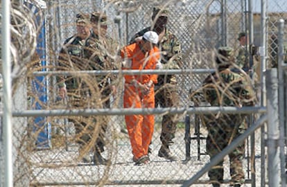 Un preso es conducido por varios militares en el campo de detención de Guantánamo.
