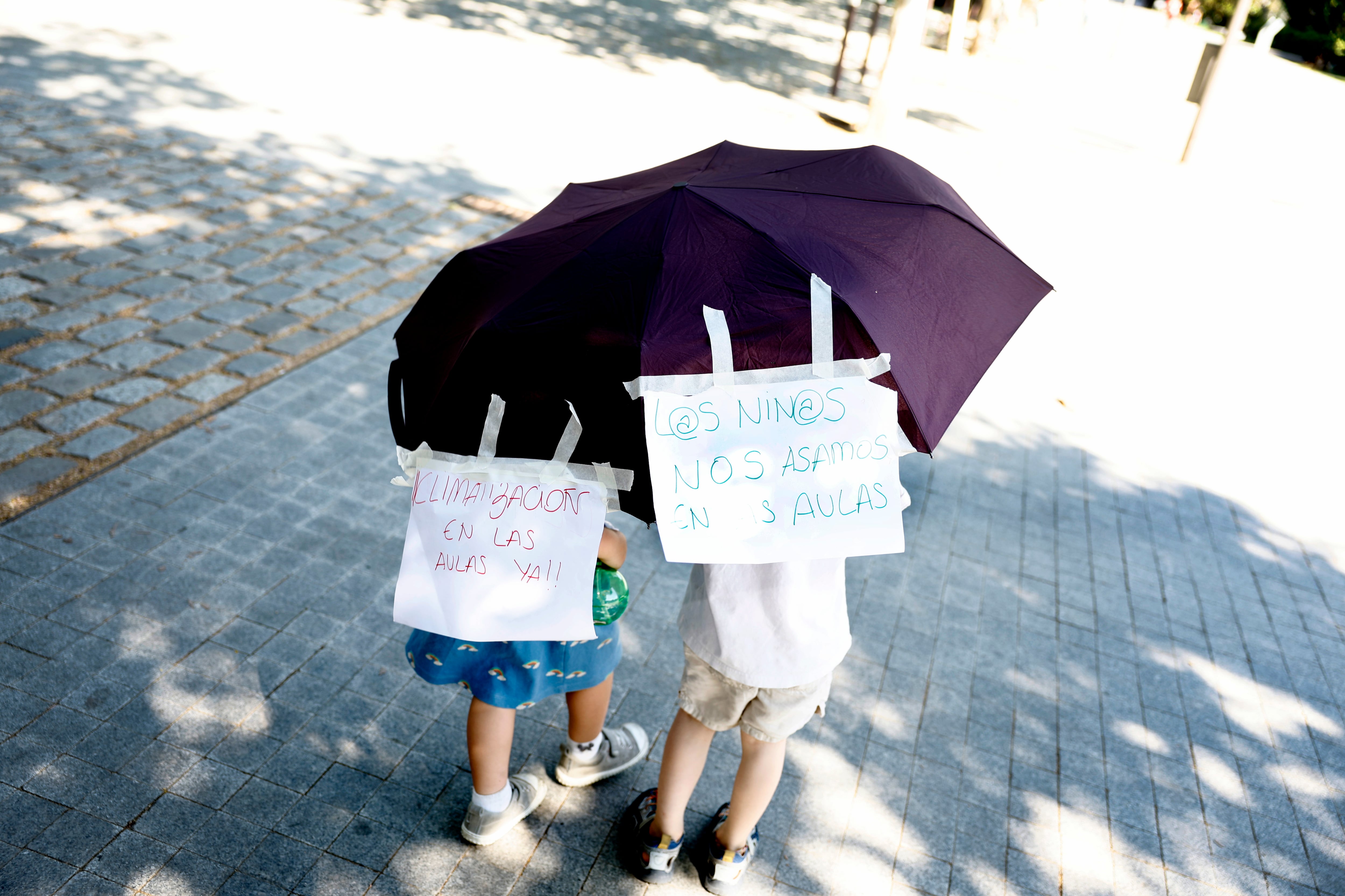 Dos niños durante la protesta de padres y alumnos en la junta municipal del distrito de Arganzuela por el calor en las aulas.