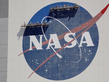 Workers on scaffolding repaint the NASA logo near the top of the Vehicle Assembly Building at the Kennedy Space Center in Cape Canaveral, Fla., May 20, 2020.