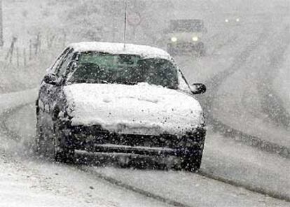 Varios coches intentan circular por la N-135 en medio de una copiosa nevada en los alrededores de la localidad navarra de Larrasoaña.