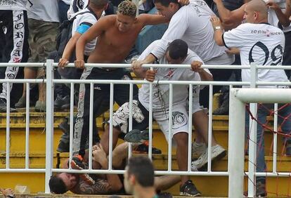 Torcedores em confronto na partida entre Vasco e Atlético Paranaense. AFP PHOTO/HEULER ANDREY