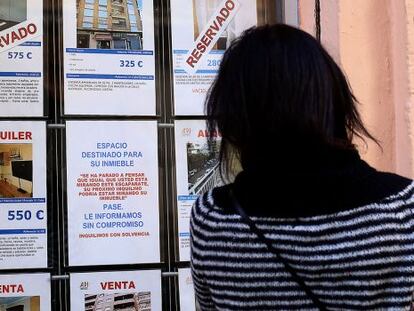 Una mujer mira los anuncios de una inmobiliaria en Valencia, en una imagen de archivo.