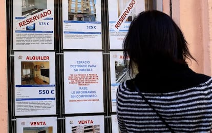 Una mujer mira los anuncios de una inmobiliaria en Valencia, en una imagen de archivo.