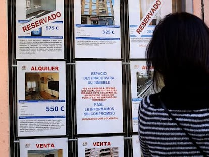 Una mujer mira el escaparte de una inmobiliaria en Valencia, en una imagen de archivo.