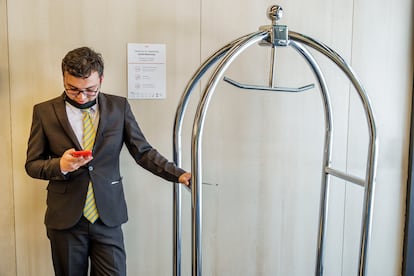 Un trabajador en un hotel de Bogotá utiliza el celular.
