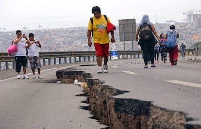 Un hombre camina por una carretera afectada por el terremoto en la ciudad de Iquique (Chile).