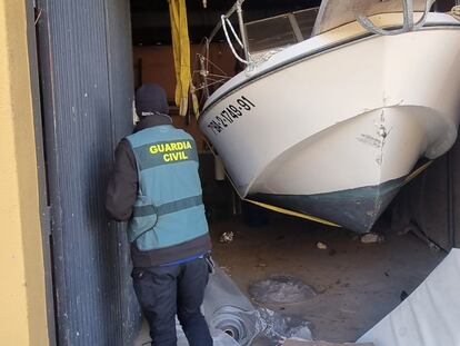 Un agente de la Guardia Civil inspecciona una de las embarcaciones intervenidas en el marco de la Operación Cabana, en la provincia de Almería.