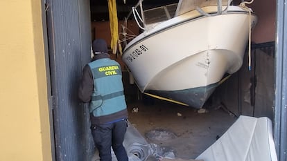 Un agente de la Guardia Civil inspecciona una de las embarcaciones intervenidas en el marco de la Operación Cabana, en la provincia de Almería.