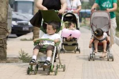 Madres pasean en carrito a sus bebés por un parque. EFE/Archivo