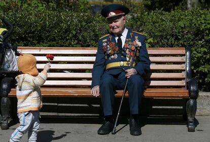 Un niño le da una flor a un veterano de la Segunda Guerra Mundial.